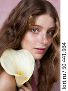 portrait mysterious freckled woman holding flower. Стоковое фото, агентство Ingram Publishing / Фотобанк Лори