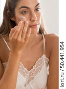 portrait woman applying cream her face. Стоковое фото, агентство Ingram Publishing / Фотобанк Лори