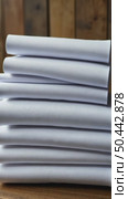 Neatly folded white t-shirts stacked on a wooden surface. Many folded white basic cotton linen presented in rustic interior. Minimalist clothing organization and clean laundry concept. Стоковое AI-видео, аниматор Sergey Grishin / Фотобанк Лори