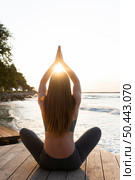 back view woman lotus meditating. Стоковое фото, агентство Ingram Publishing / Фотобанк Лори