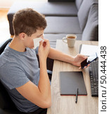 man home quarantine checking smartphone working. Стоковое фото, агентство Ingram Publishing / Фотобанк Лори