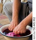 man soaking cloth pink natural pigment. Стоковое фото, агентство Ingram Publishing / Фотобанк Лори