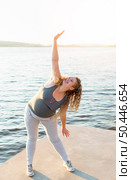 woman stretching by lake. Стоковое фото, агентство Ingram Publishing / Фотобанк Лори