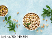 Pistachios. Whole pistachios with green leaves and pistachio nut kernels. Healthy natural vegetarian organic food. Top view, copy space. Стоковое фото, агентство Ingram Publishing / Фотобанк Лори