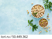Pistachios. Whole pistachios with green leaves and pistachio nut kernels. Healthy natural vegetarian organic food. Top view, copy space. Стоковое фото, агентство Ingram Publishing / Фотобанк Лори