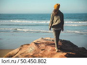 Woman with a yellow cap and walking over a cliff to see the beach. Стоковое фото, агентство Ingram Publishing / Фотобанк Лори