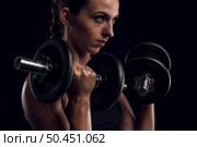 Shot of a beautiful young woman in a workout gear lifting weights. Стоковое фото, агентство Ingram Publishing / Фотобанк Лори