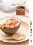Yogurt with grapefruit, granola, chia and honey served in half a coconut shell on a rose marble kitchen countertop. Стоковое фото, агентство Ingram Publishing / Фотобанк Лори