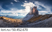 Mountain pass and blue sky with clouds at sunset in autumn. Beautiful panoramic landscape with rocks, alp mountains, stones, path, house, grass on hills. Tre Cime, Dolomites, Italy. Colorful scenery. Стоковое фото, агентство Ingram Publishing / Фотобанк Лори