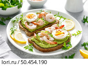 Toast with shrimps, avocado guacomole, arugula and boiled egg. Стоковое фото, агентство Ingram Publishing / Фотобанк Лори