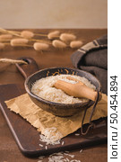 Basmati rice in ceramic bowl with wooden scoop on rustic countertop. Стоковое фото, агентство Ingram Publishing / Фотобанк Лори