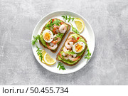 Toast with shrimps, avocado guacomole, arugula and boiled egg, top view. Стоковое фото, агентство Ingram Publishing / Фотобанк Лори