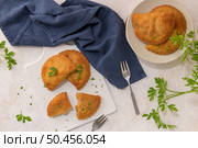 Meat patties and parsley leaves on white ceramic dishes in a kitchen counter top. Стоковое фото, агентство Ingram Publishing / Фотобанк Лори