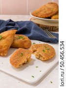 Meat patties and parsley leaves on white ceramic dishes in a kitchen counter top. Стоковое фото, агентство Ingram Publishing / Фотобанк Лори