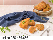Meat patties and parsley leaves on white ceramic dishes in a kitchen counter top. Стоковое фото, агентство Ingram Publishing / Фотобанк Лори