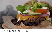 Healthy vegan burger with fresh vegetables and yogurt sauce on rustic kitchen counter top. Стоковое фото, агентство Ingram Publishing / Фотобанк Лори