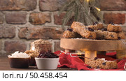 Cereal bars with almonds, coconut and cranberries on a Christmas season table decorated with lights. Стоковое фото, агентство Ingram Publishing / Фотобанк Лори