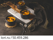 Creme brulee. Bowls with French vanilla cream dessert with caramelised sugar on top, spoons, dark rustic table. Стоковое фото, агентство Ingram Publishing / Фотобанк Лори