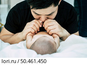 A young Asian father is sniffing his newborn baby. Стоковое фото, агентство Ingram Publishing / Фотобанк Лори
