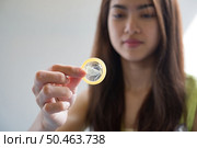 Young woman holding condom prevent pregnancy and Sexually transmitted diseases. Стоковое фото, агентство Ingram Publishing / Фотобанк Лори