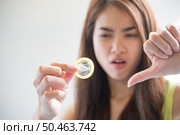 Young woman holding condom prevent pregnancy and Sexually transmitted diseases. Стоковое фото, агентство Ingram Publishing / Фотобанк Лори