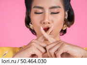 Beauty asian woman red lips and finger showing hush silence sign. Стоковое фото, агентство Ingram Publishing / Фотобанк Лори