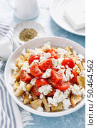 Dakos or koukouvagia salad. Classic recipe Cretan barley rusk salad with fresh tomato, mizithra cheese and oregano. Traditional mediterranean Greek cuisine. Healthy food, diet. Стоковое фото, агентство Ingram Publishing / Фотобанк Лори