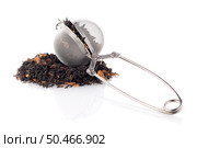 Aromatic black dry tea with petals and a tea strainer on white reflective background. Стоковое фото, агентство Ingram Publishing / Фотобанк Лори