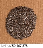 Top view of  chia seeds against brown vinyl background. Стоковое фото, агентство Ingram Publishing / Фотобанк Лори