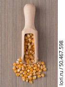 Top view of wooden scoop with corn against beige vinyl background. Стоковое фото, агентство Ingram Publishing / Фотобанк Лори