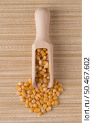 Top view of wooden scoop with corn against beige vinyl background. Стоковое фото, агентство Ingram Publishing / Фотобанк Лори