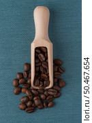 Top view of wooden scoop with coffee beans against blue vinyl background. Стоковое фото, агентство Ingram Publishing / Фотобанк Лори