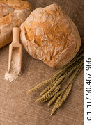Rustic bread and wheat on an old vintage planked wood table. Стоковое фото, агентство Ingram Publishing / Фотобанк Лори