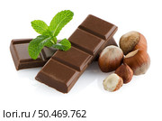 Closeup detail of chocolate parts, hazelnuts and mint leaves on white background. Стоковое фото, агентство Ingram Publishing / Фотобанк Лори