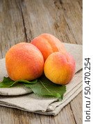 Apricots with leaves on the wooden table. Стоковое фото, агентство Ingram Publishing / Фотобанк Лори