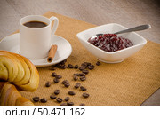 Cup of black coffee and croissant over sackcloth baclground. Стоковое фото, агентство Ingram Publishing / Фотобанк Лори