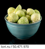Fresh brussels sprouts on blue ceramic bowl isolated on black background. Стоковое фото, агентство Ingram Publishing / Фотобанк Лори