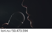 Male Mouth Singing into Microphone on Dark Stage Under Spotlight. Стоковое видео, видеограф Илья Шаматура / Фотобанк Лори