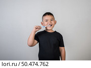 Little boy brushing his teeth in studio photo. Стоковое фото, агентство Ingram Publishing / Фотобанк Лори