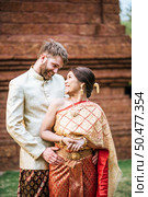 Asian bride and Caucasian groom have romantic time with Thailand dress. Стоковое фото, агентство Ingram Publishing / Фотобанк Лори