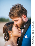Asian bride and Caucasian groom have romance time and happy together . Стоковое фото, агентство Ingram Publishing / Фотобанк Лори