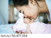 The newborn baby sleeping in the mother’s arms and fragrant on the baby’s forehead. Стоковое фото, агентство Ingram Publishing / Фотобанк Лори