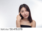 Women wearing black strapless blouses and hands touching the face on the eyebrows. Стоковое фото, агентство Ingram Publishing / Фотобанк Лори