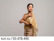 Women wearing Thai clothes and right hand grasping her shoulders. Стоковое фото, агентство Ingram Publishing / Фотобанк Лори