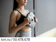 Women exercise with Dumbbell weight plates in the chest. Стоковое фото, агентство Ingram Publishing / Фотобанк Лори
