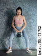 Asian girls are exercising with the Kettlebell in the gym. Стоковое фото, агентство Ingram Publishing / Фотобанк Лори