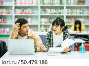 Women read books and men use laptops to search for books in libraries. Стоковое фото, агентство Ingram Publishing / Фотобанк Лори