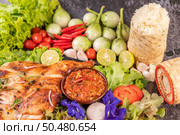 Grilled chicken on a plate with sticky rice, chilies, garlic sauce and sprinkled with pepper seeds. Стоковое фото, агентство Ingram Publishing / Фотобанк Лори