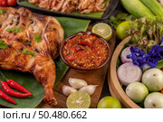 Grilled chicken on a plate with chili peppers, garlic sauce and sprinkled with pepper seeds. Стоковое фото, агентство Ingram Publishing / Фотобанк Лори