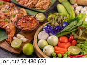 Grilled chicken on a plate with chili peppers, garlic sauce and sprinkled with pepper seeds. Стоковое фото, агентство Ingram Publishing / Фотобанк Лори